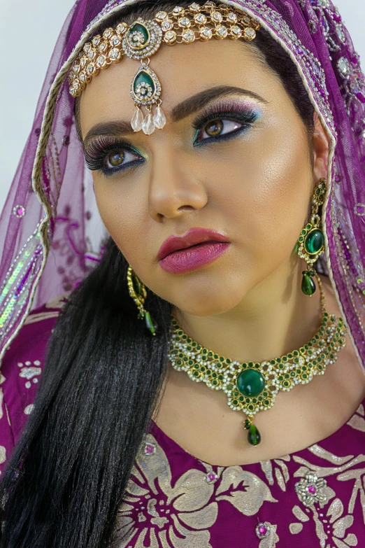 a woman with dark blue makeup in purple dress