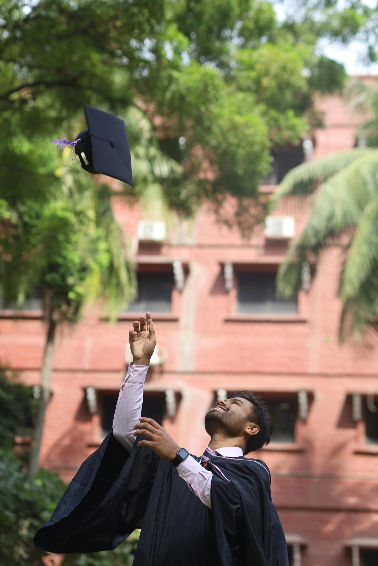 a graduate tossing his cap in the air