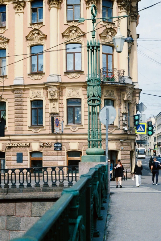 people walking down a sidewalk between old buildings