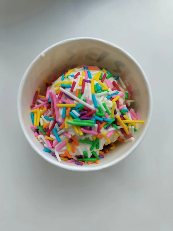 a bowl filled with white and rainbow sprinkles