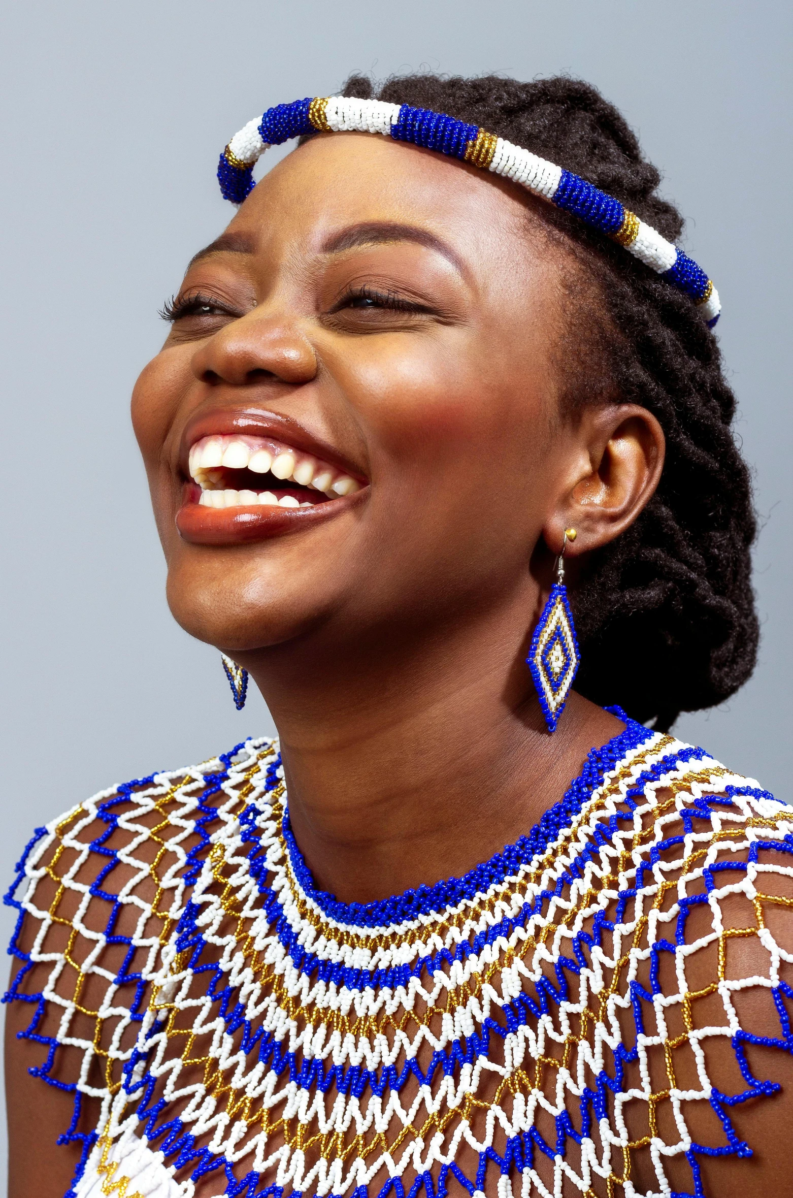 the model wears a colorful necklace and earrings