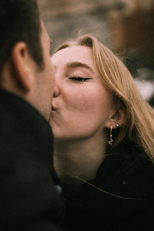 a woman is kissing a man in the street