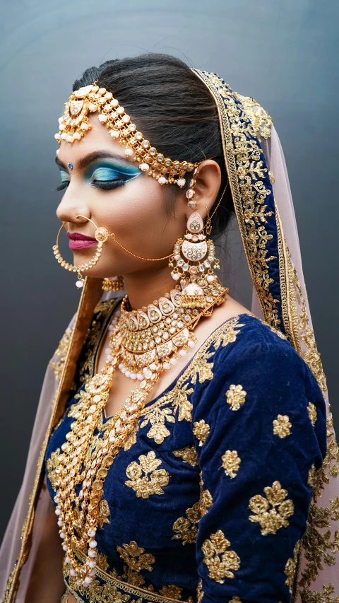 a woman in blue and gold with jewellery on her forehead