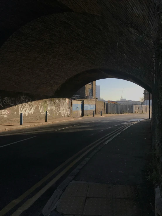 an empty street with a long bridge in the distance