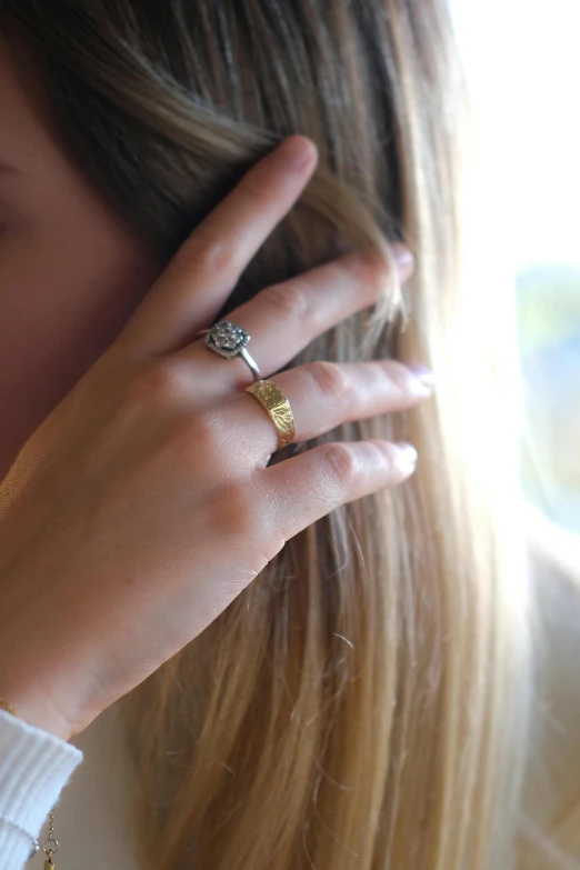a woman is wearing her ring while she looks off into the distance