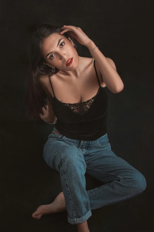 a young woman in jeans and a black shirt poses in front of the camera