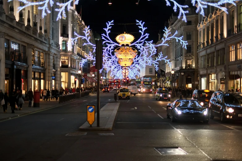 cars driving down the street covered in christmas lights