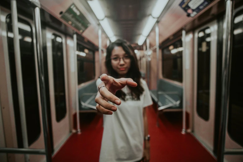 a girl on a subway pointing her finger