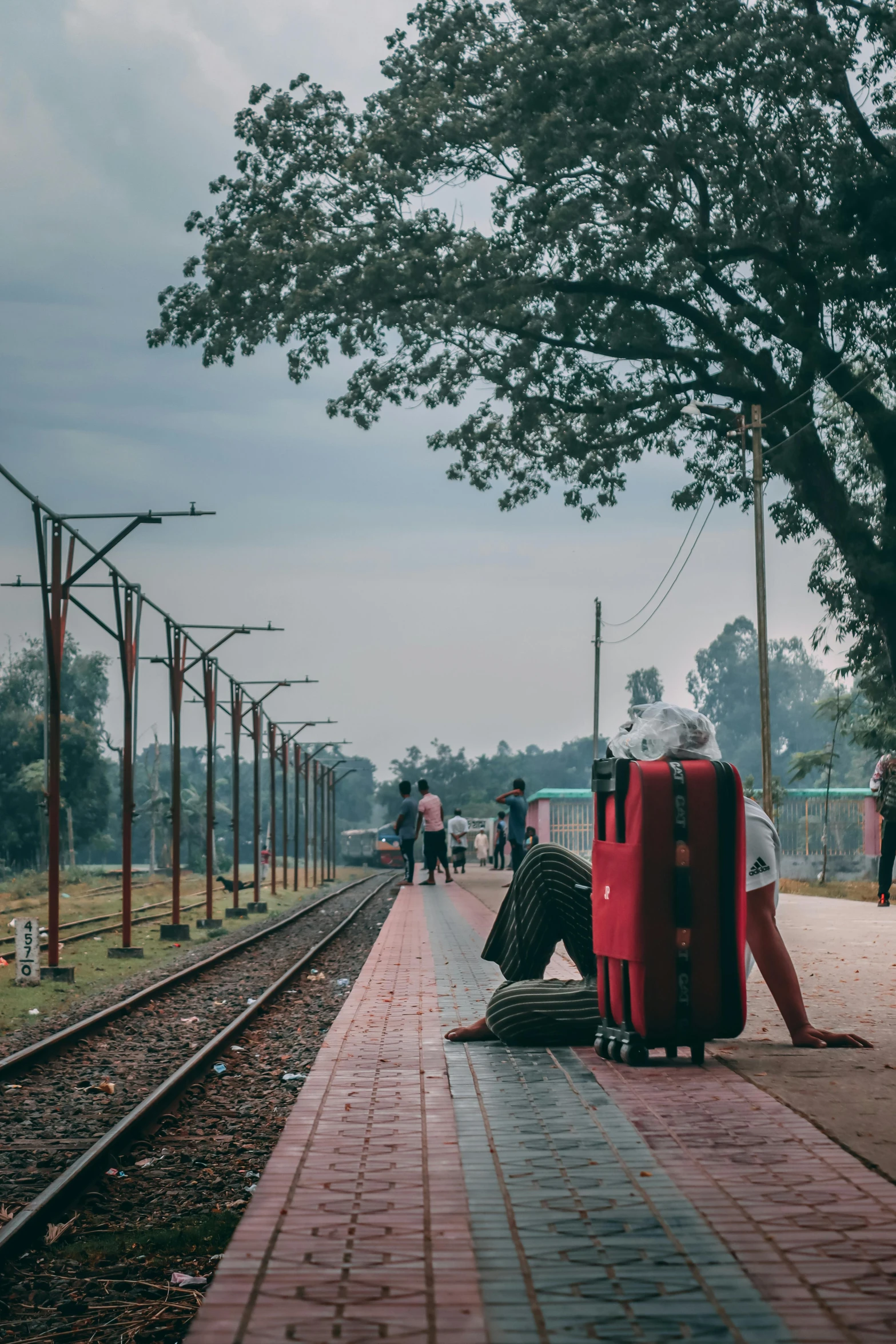 a pair of suitcases sitting on the side of the train track