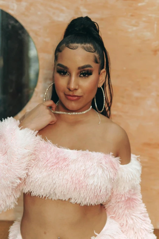 a woman in a pink fluffy jacket and silver earrings