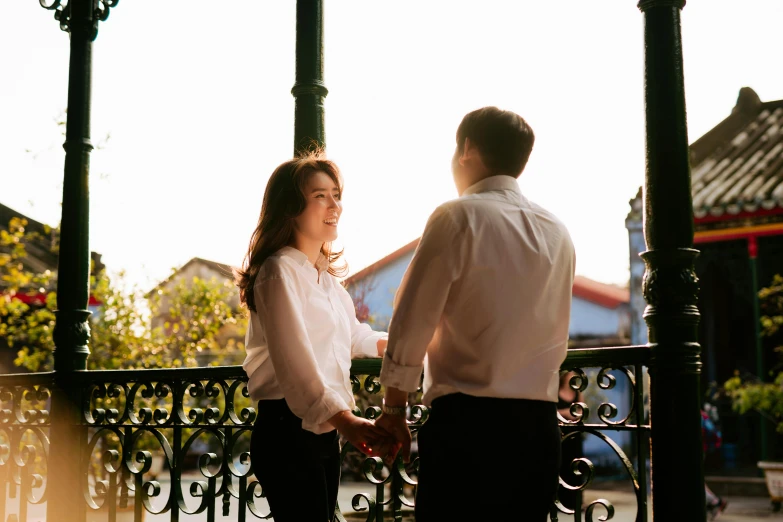 a woman and man standing next to each other outside