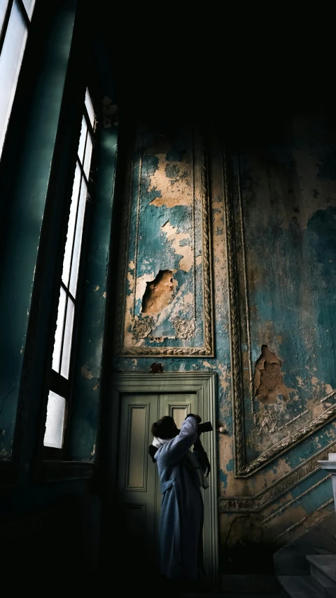 a person with an umbrella standing in an abandoned room