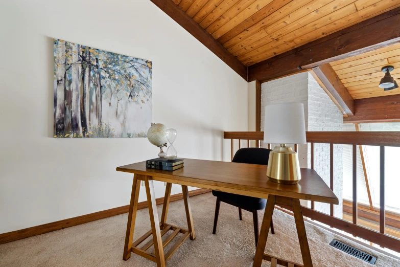 a nice wooden desk in the corner of an empty room