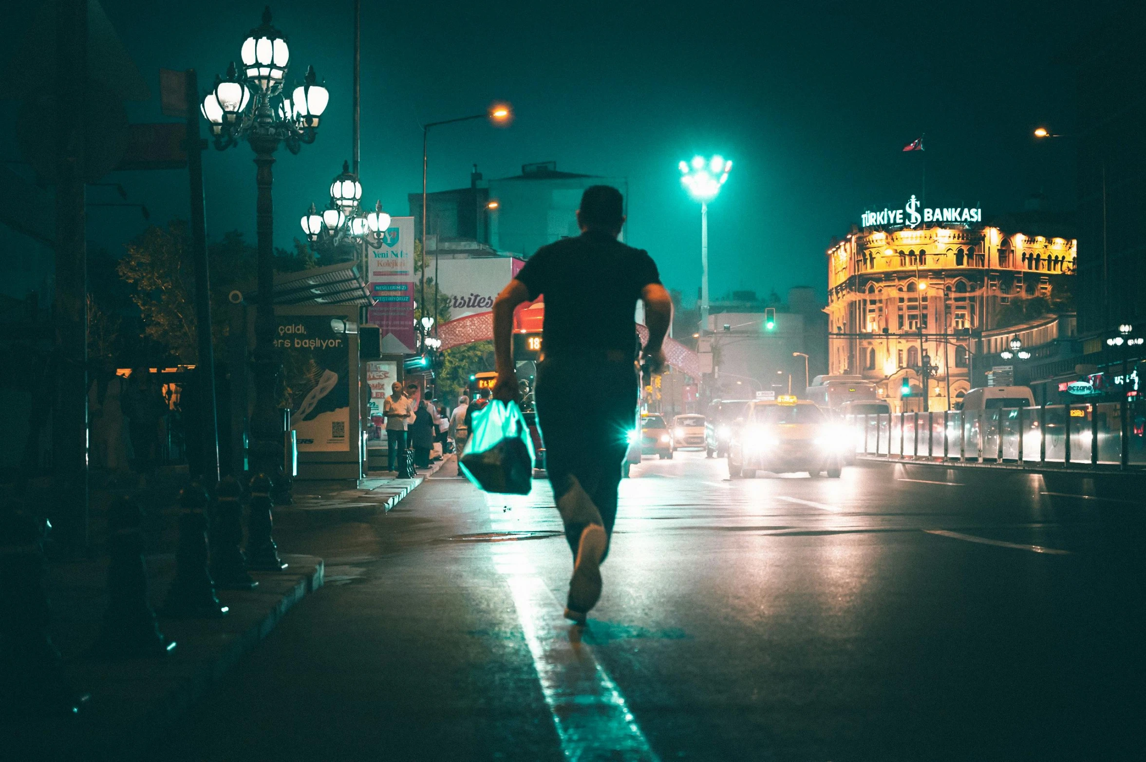 man running on city street at night with traffic lights