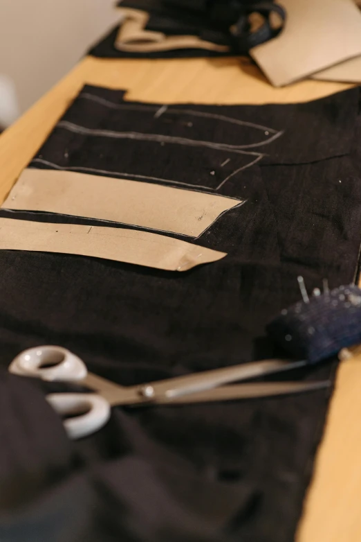 scissors laying on a table with pieces of fabric