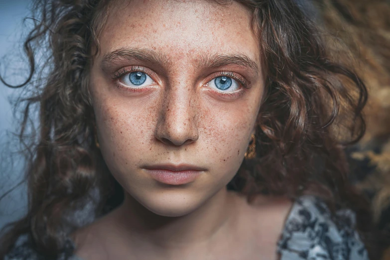 the woman is posing for the camera with freckle on her face