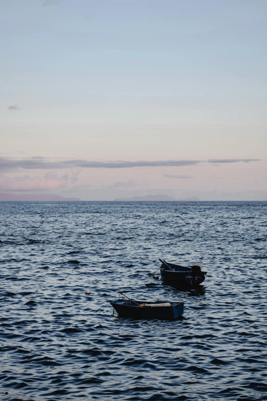 two boats are in the middle of the ocean