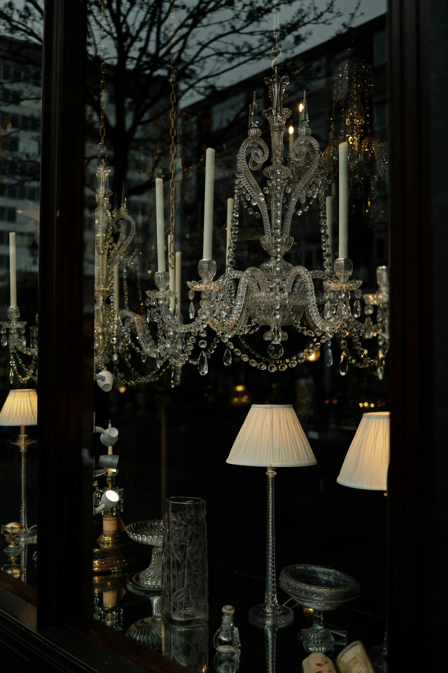 a chandelier and some lamps in front of a window