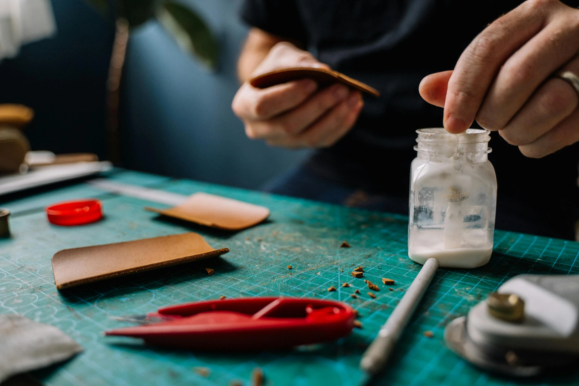 a person  pieces off a jar containing some crafting supplies