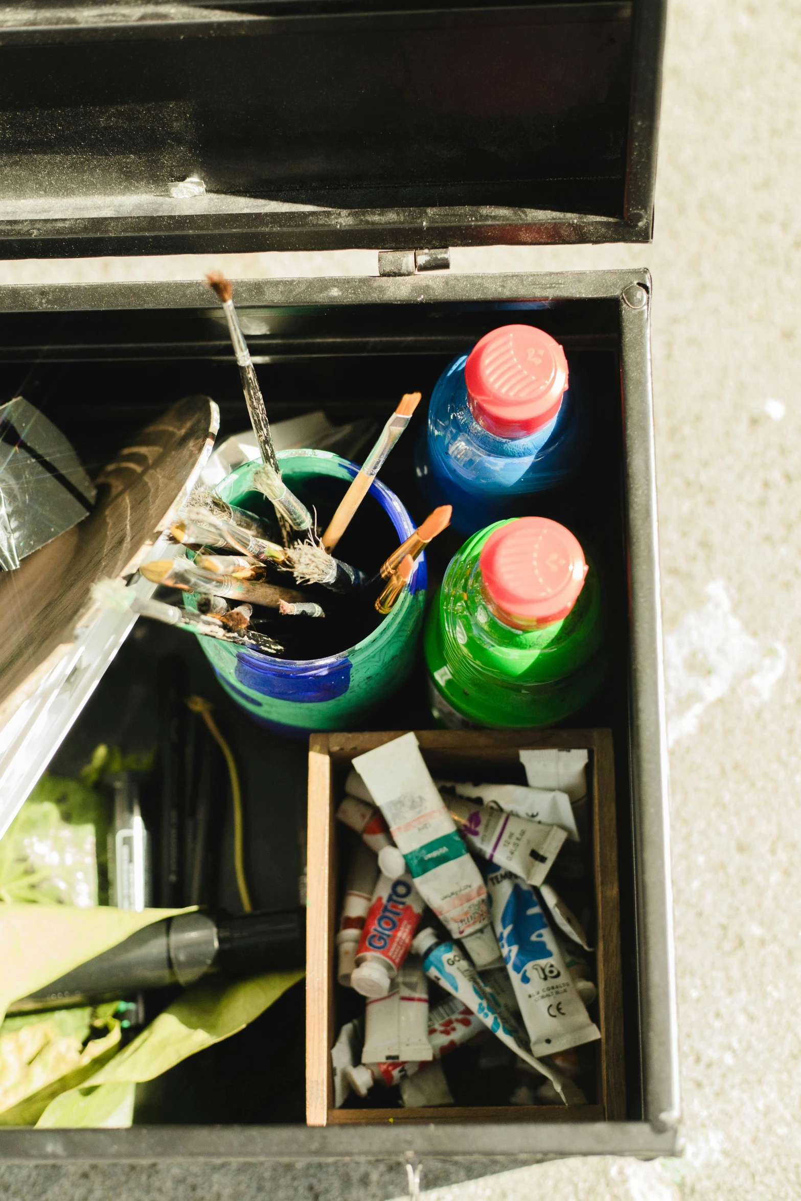 a metal box holds art supplies and brush