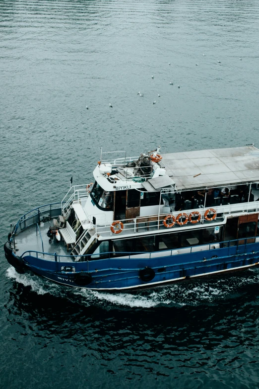 a blue and white boat sailing on the water