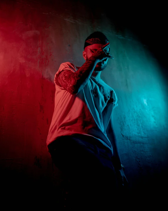 a man with tattoos on his arms and hand holding a cell phone up to his ear