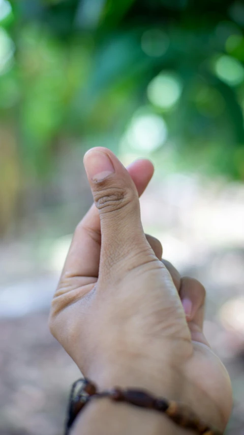 a small piece of jewelry in the middle of a hand