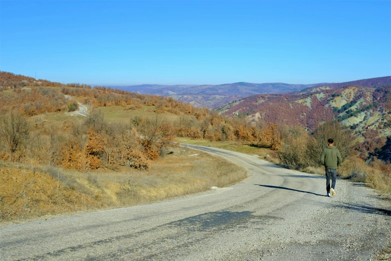 a person that is standing on a gravel road