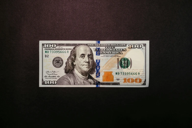 a po of a ten dollar bill on a black table