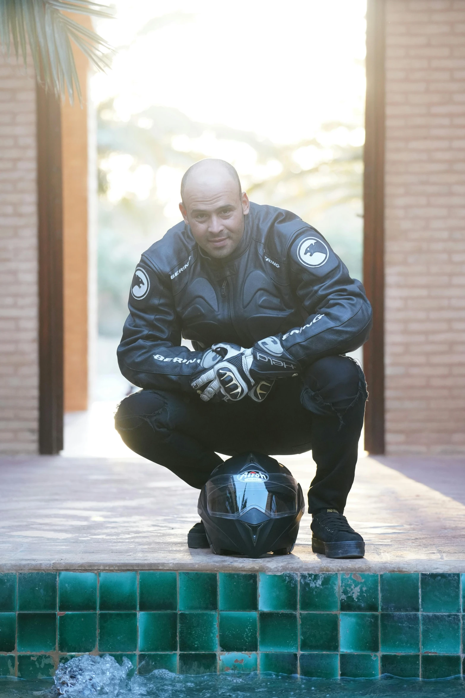 a man wearing a protective gear kneeling by a pool