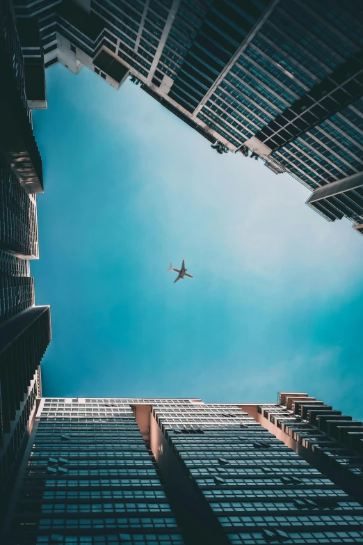 an airplane flying in the sky over a tall building