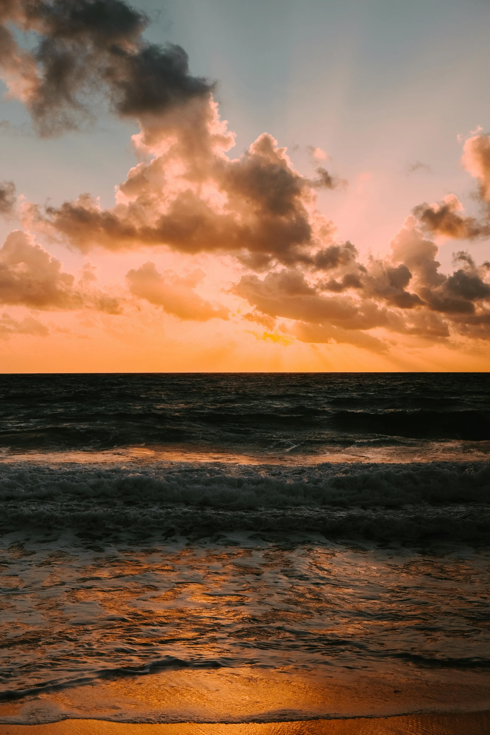 the sun shining in through some clouds over the water