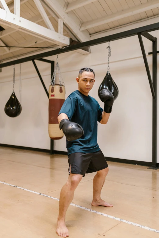 a young man is practicing boxing inside