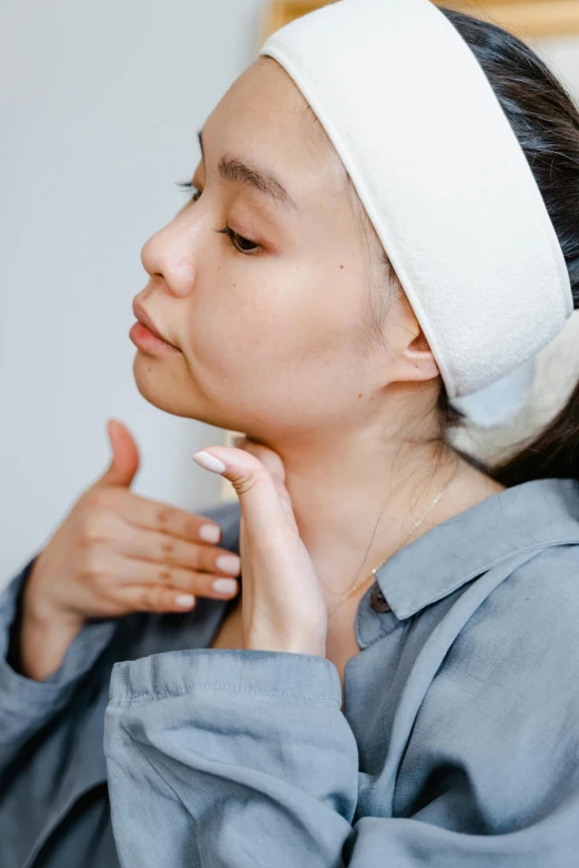 a woman is holding up a white piece of fabric to her face