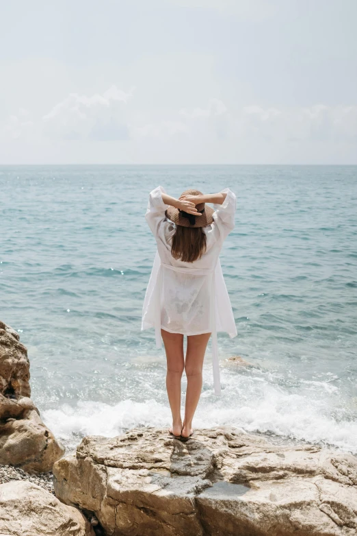 a woman is standing on rocks in the water