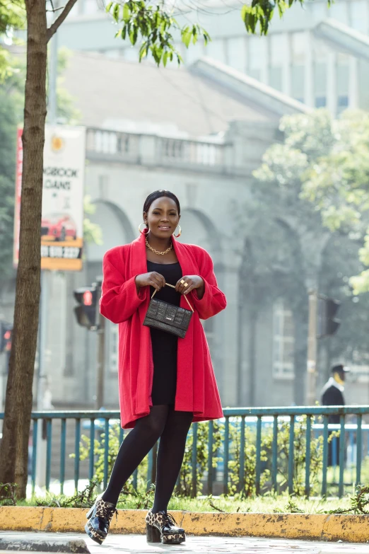 a woman in a pink jacket is standing on the sidewalk