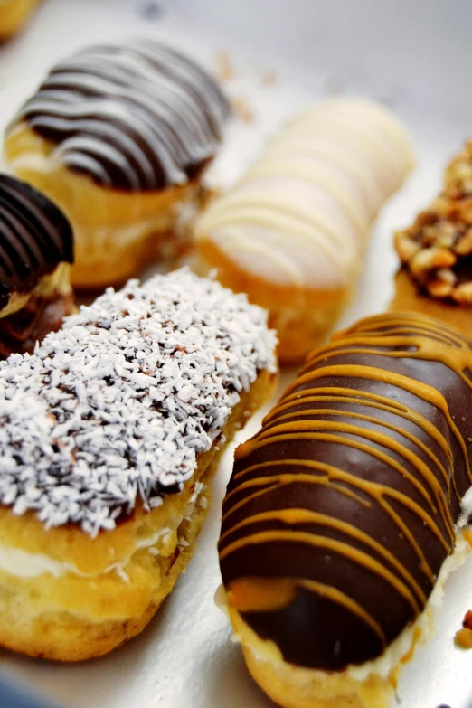 different donuts lined up in a box to be eaten