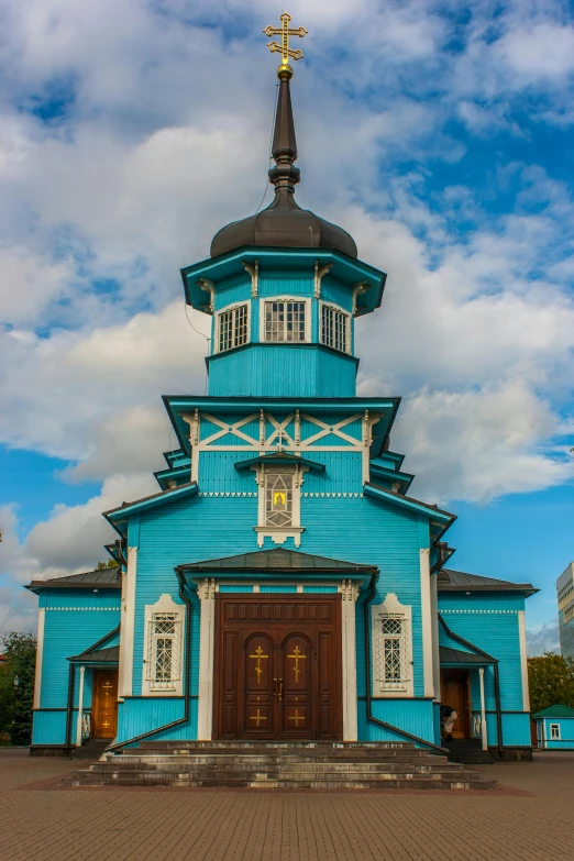 a blue and white church sitting under a cloudy sky