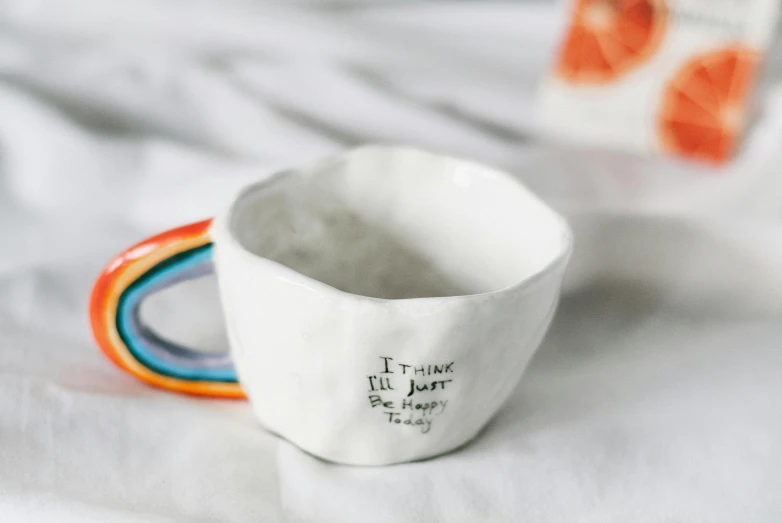 a small white cup that has a rainbow inside
