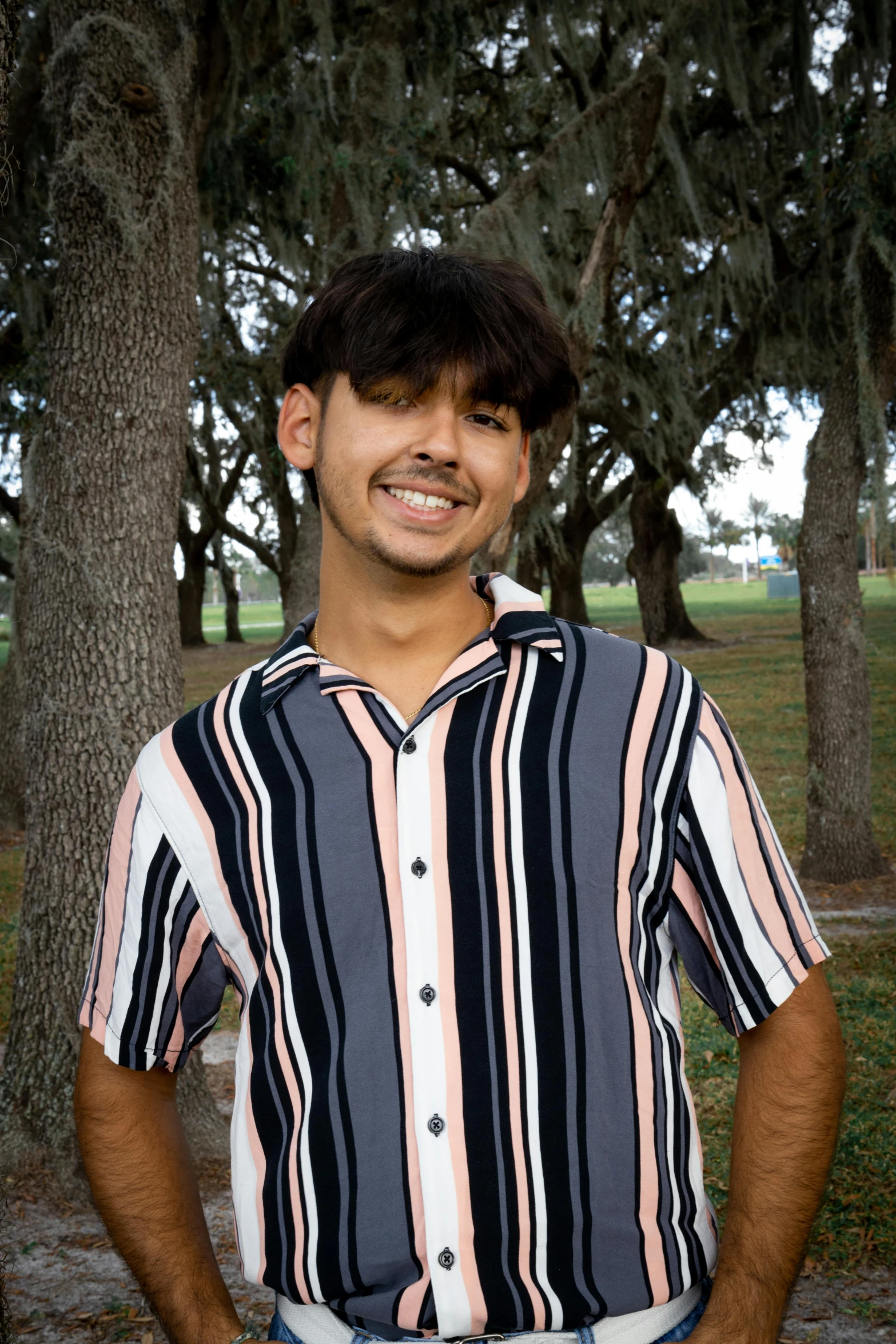 a young man in an orange, black and white striped shirt