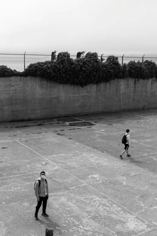 two men standing in an empty concrete field