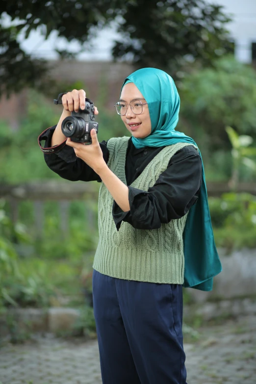 woman wearing green and black clothing taking pictures