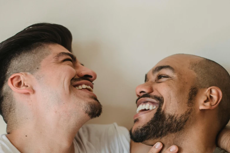 two young men are laughing next to each other