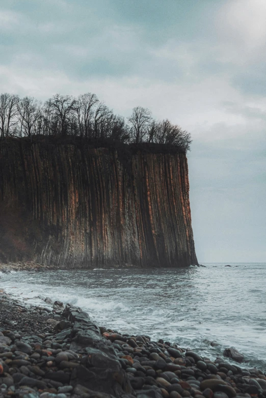 two people are standing near the water in front of an island