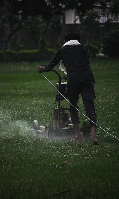 a person spraying grass with a lawn mower