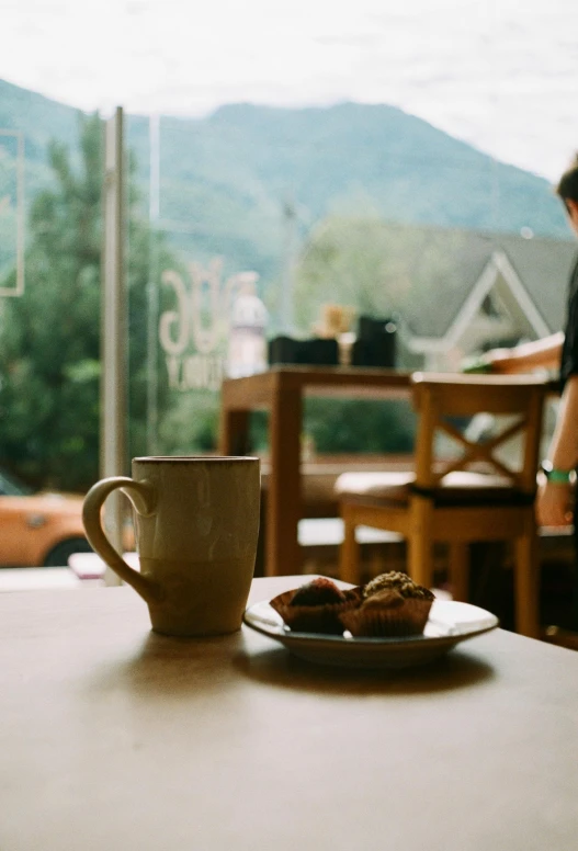 a coffee cup sitting next to a plate with some food on it