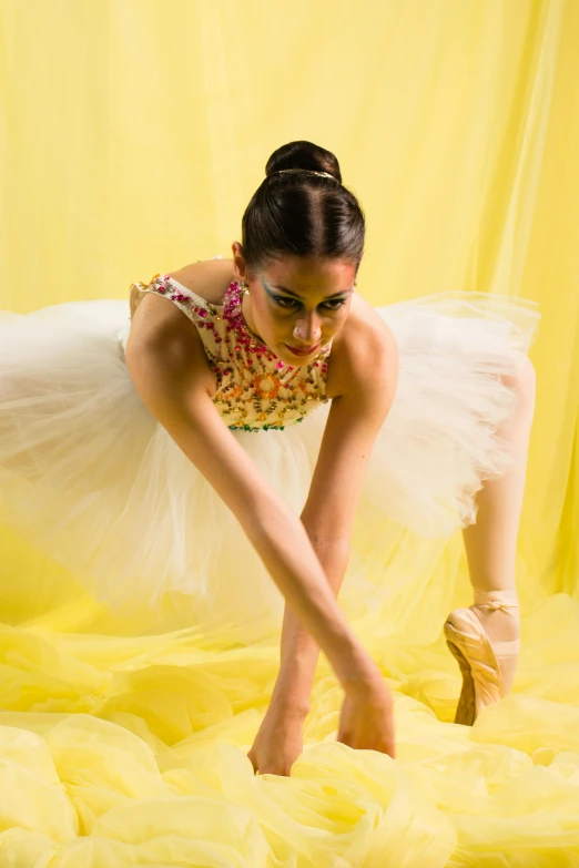 a dancer in a yellow dress poses for a po