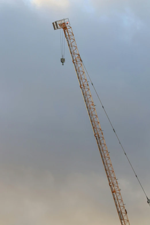 a crane holding a large flag is high in the air