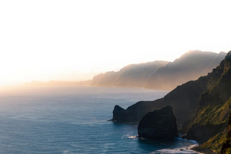 cliffs near the ocean at sunrise with sun lighting them up