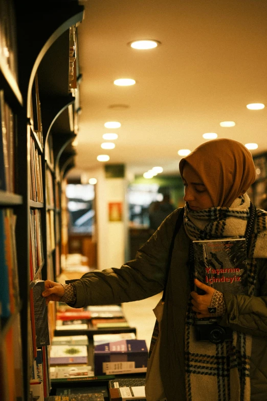 two women checking out books on a shelf in a liry